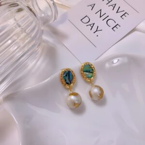 Pendientes colgantes de concha de paua y perla dorada.