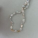 Collar con perlas de agua dulce de forma irregular chapado en oro de 18 quilates y detalles sobre monedas.