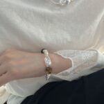 Collier de perles d'ambre et de perles baroques présenté à la main