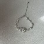 Collier baroque en perles avec pendentif disque rond et présentation latérale