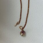 Collier de perles de grenat avec pendentif en perle baroque irisée (vue de face)