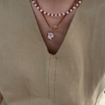 Collier de perles de grenat avec pendentif en perle baroque irisée sur présentoir