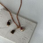 Collier de perles de grenat avec pendentif en perle baroque irisée.