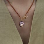 Collier de perles de grenat avec pendentif en perle baroque irisée et présentation latérale