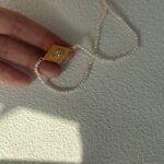 Collier de perles œil-grec avec pendentif argenté plaqué or et détails apparents