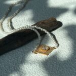 Collier de perles œil-de-grec avec pendentif en argent plaqué or