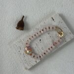 Collier pendentif en quartz rose et perles baroques sur présentoir