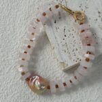 Collier pendentif en quartz rose et perles baroques, présentation latérale