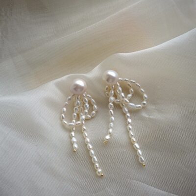 Boucles d'oreilles en perles d'eau douce à pompons, serties de perles S925 et réalisées à la main. Détails soignés.