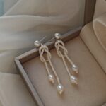 Detalles de los pendientes de nudo tejido con perlas de agua dulce y plata 925