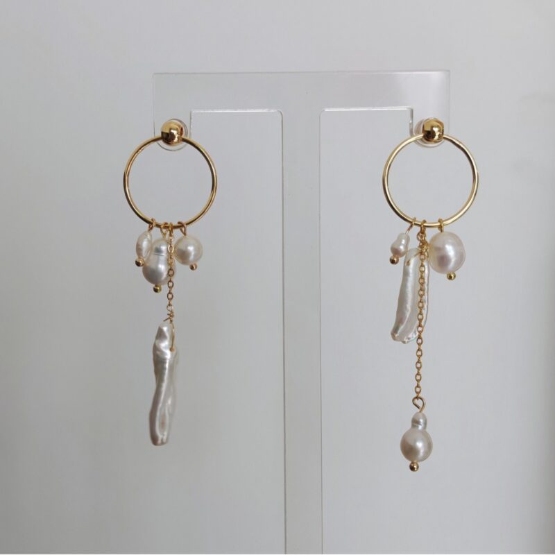 Boucles d'oreilles asymétriques en perles d'eau douce à pompons - Détails sculptant le visage