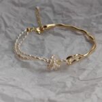 Pulsera ajustable de tono dorado, anudada a mano con perlas de agua dulce