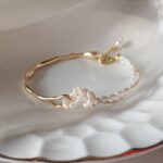 Pulsera ajustable de perlas de agua dulce anudada a mano en tono dorado con detalles