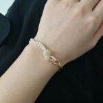 Pulsera ajustable de perlas de agua dulce anudada a mano en tono dorado con detalles sobre
