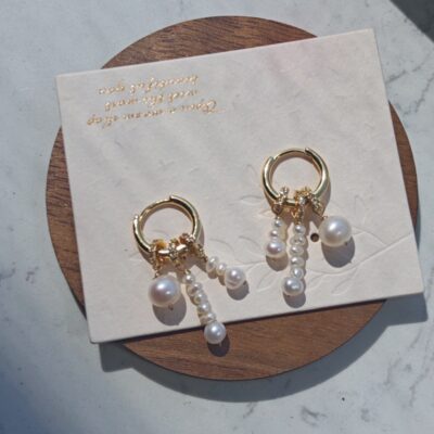 Pendientes de aro pequeños con perlas de agua dulce chapados en oro y detalles asimétricos.
